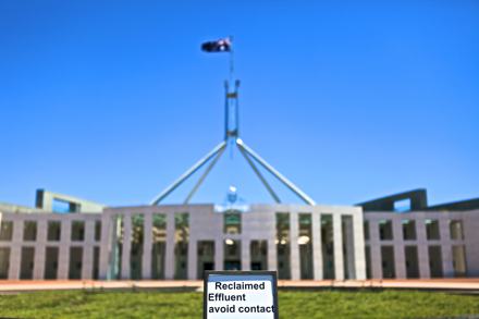 Photo of the front of Parliament House Canberra. There is a large fountain out the front of parly that’s filled with recycled water which has been completely cut out of the foreground of this photo. But included in the photo is the top of a sign placed within the fountain that reads “Recycled effluent, avoid contact.”